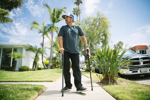 Eddie King walking with walking sticks on sidewalk
