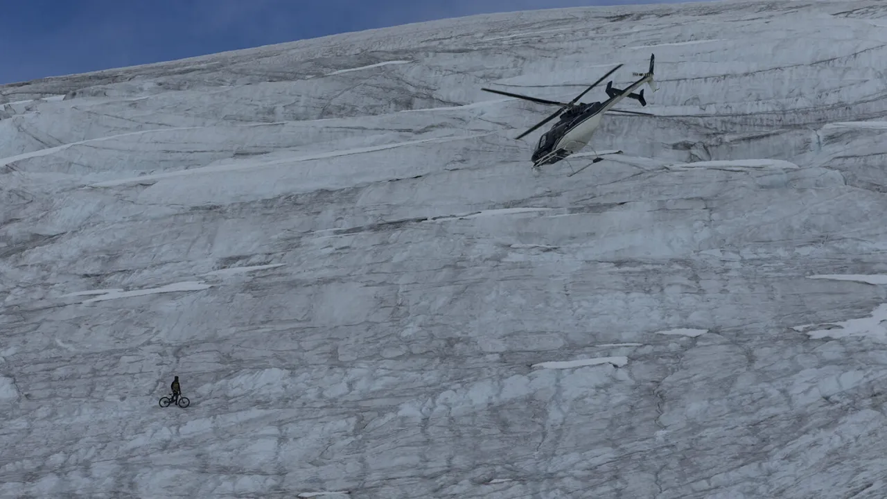 Aggy prepares to drop into the Pemberton Ice cap while a GSs-mounted helicopter looks on, British Columbia in July 2014