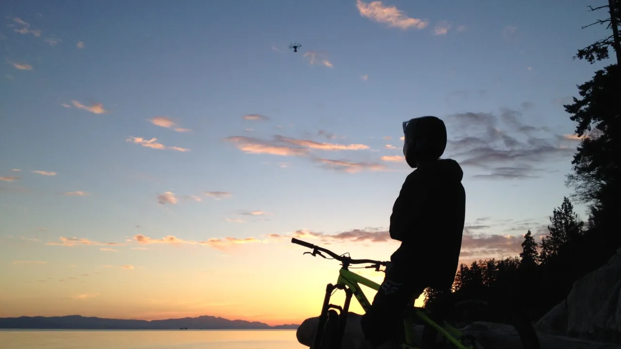 Pro mountain biker, Brett Rheeder watches on from a beach at sunrise on the Sunshine Coast after completing the final scene from his unReal night segment.