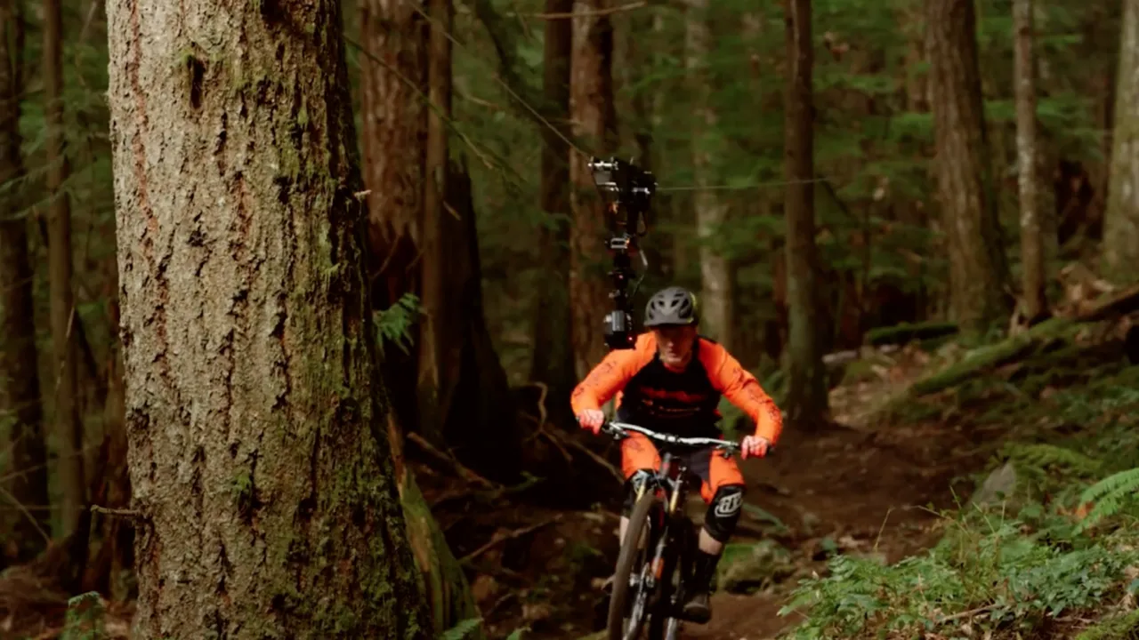 Tom van Steenbergen descends a trail in Squamish BC with Anthill's remote cable camera tracking in front.