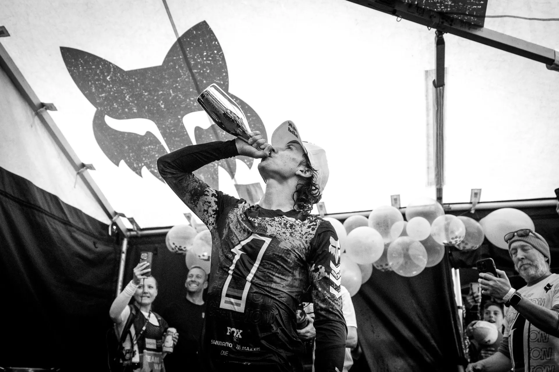 Jackson Goldstone chugs a bottle of Champagne in #1 jersey after winning 2025 UCI DH Overall Title